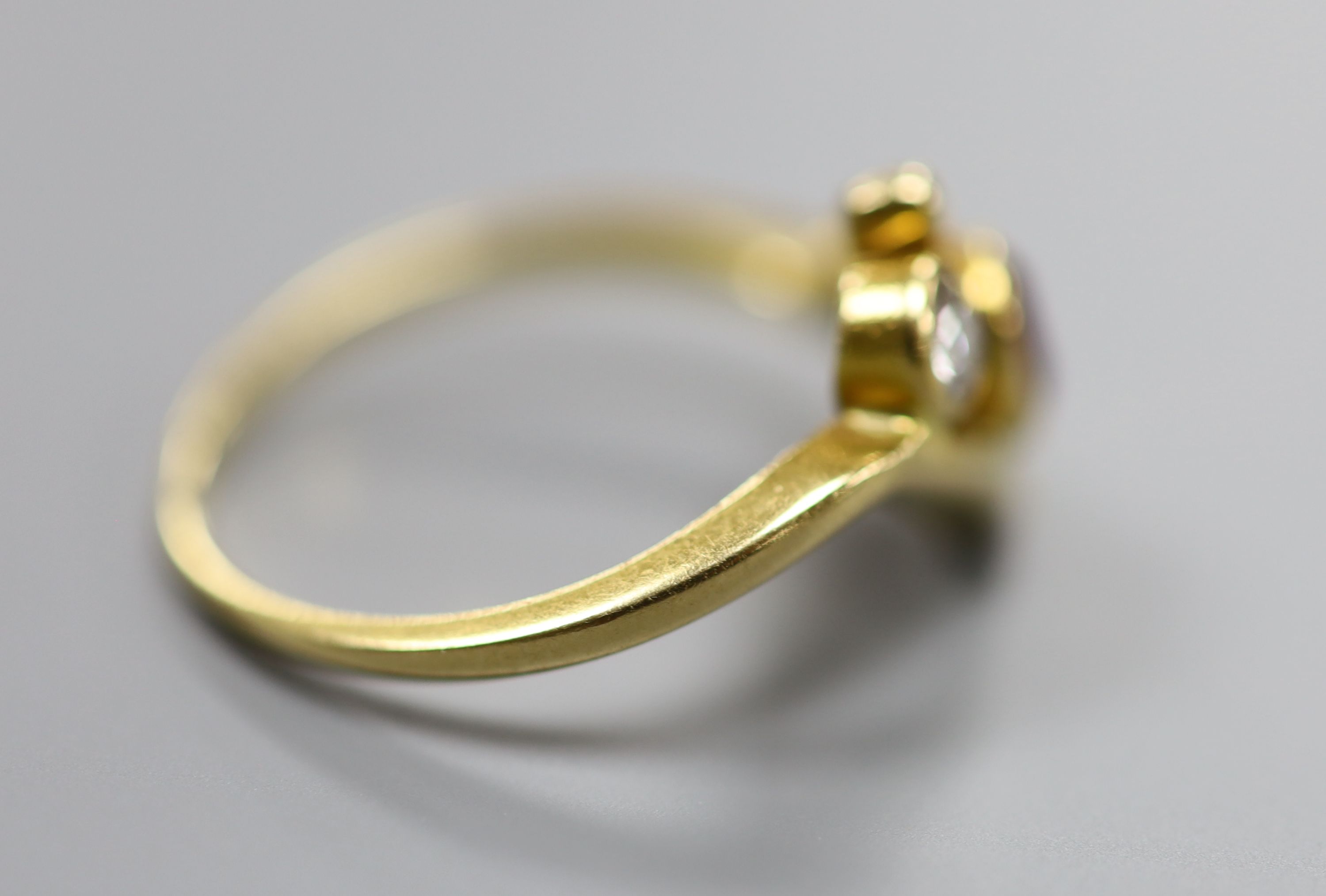 A 750 yellow metal, ruby and diamond three stone crossover ring, size P, gross 4 grams.